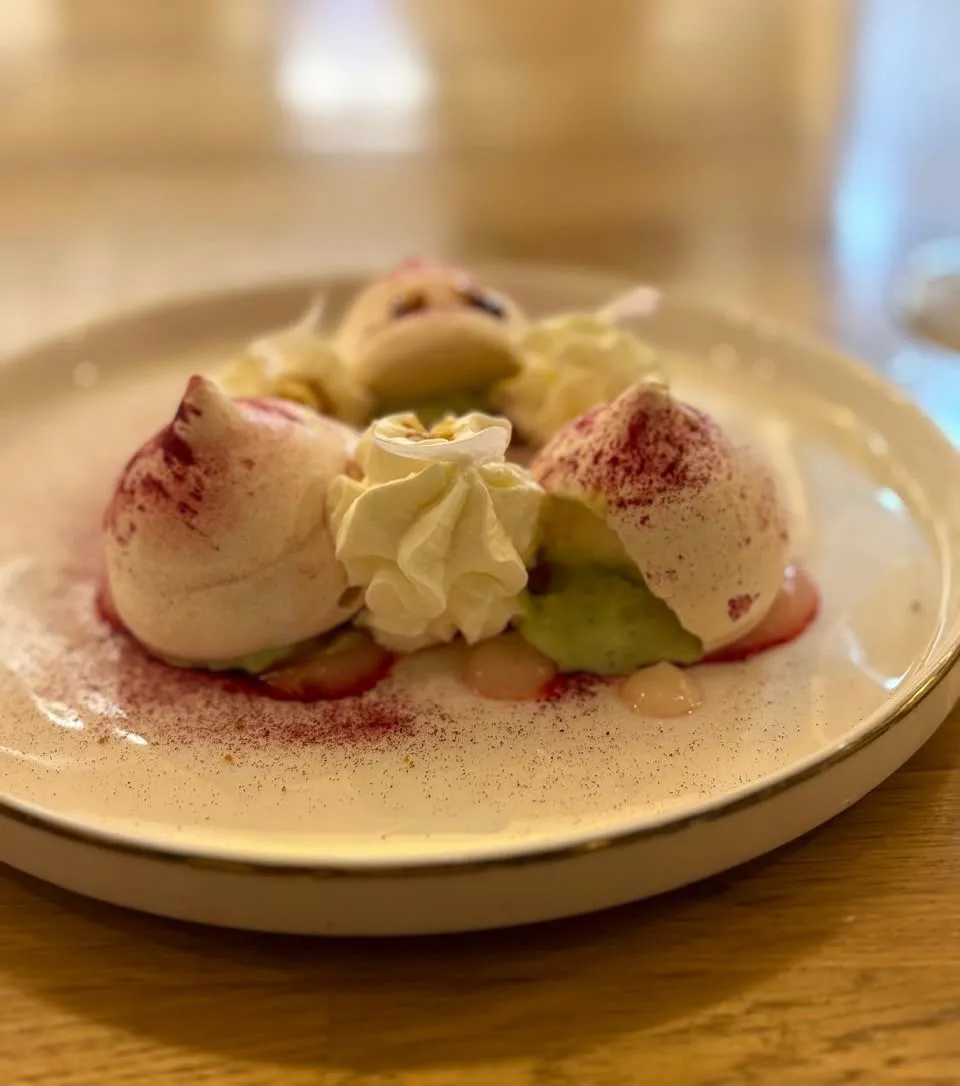 Meringues, whipped cream, pistachio cream, raspberry dust.
